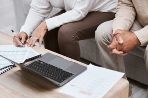 Casal discutindo terceirização financeira no laptop.